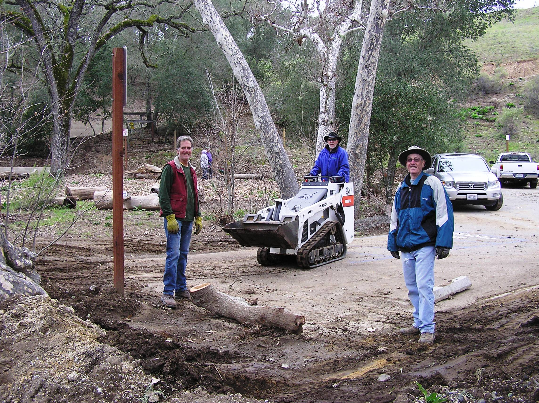 Clearing mud and silt from the ADA parking space.